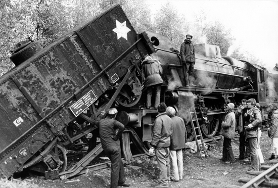 Oswald Morris, BSC, debout sur le rebord de la locomotive, et Alex Thomson, de profil tenant une caméra - sur le tournage de <i>The Seven-Per-Cent Solution</i> d'Herbert Ross en 1976<br class='manualbr' />(Document BSC)