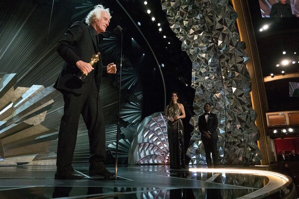 Roger Deakins sur scène lors de la 90<sup class="typo_exposants">e</sup> cérémonie des Oscars, recevant l'Oscar de la Meilleure photographie des mains de Sandra Bullock. - (Photo avec l'aimable autorisation de l'AMPAS)