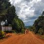 La route en latérite et l'entrée de l'école 