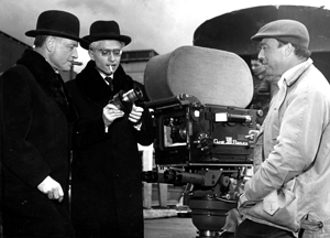Pierre Fresnay, Dary Cowl tenant le prototype du premier zoom Angénieux, le Camé 300 Reflex et Roger Fellous