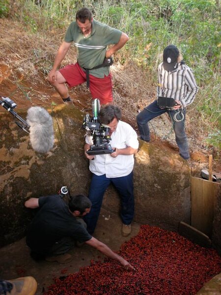 Yves Cape, with the camera handheld, behind and above him Maxime Cointe, assistant cameraman, and Claire Denis during filming of "White Material"