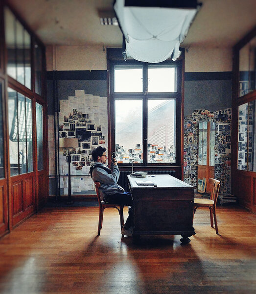 Noé Bach mesurant la lumière dans le décor du bureau - Photo Hélène Defline