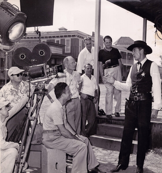 Homer Plannette (long sleeve white shirt in the background), cinematographer Floyd Crosby (standing close camera left), and Gary Cooper on the set of "High Noon", in 1952