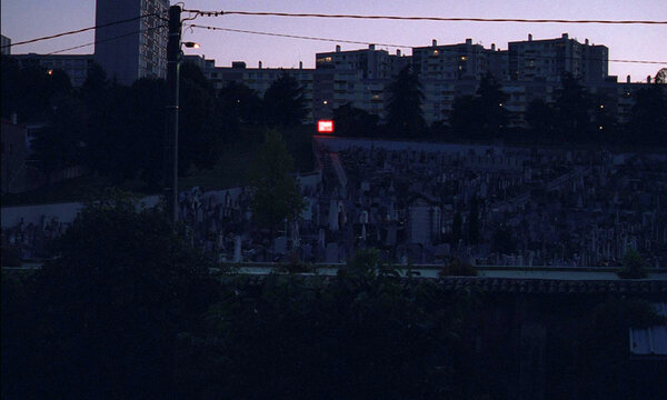 Le point de vue de la fenêtre de chez les Géquil - Cimetière, terrain de jeu, lumière rouge, comme un repère. Circulation, récurrence, horaires... La géographie d'un film et ses obsessions.