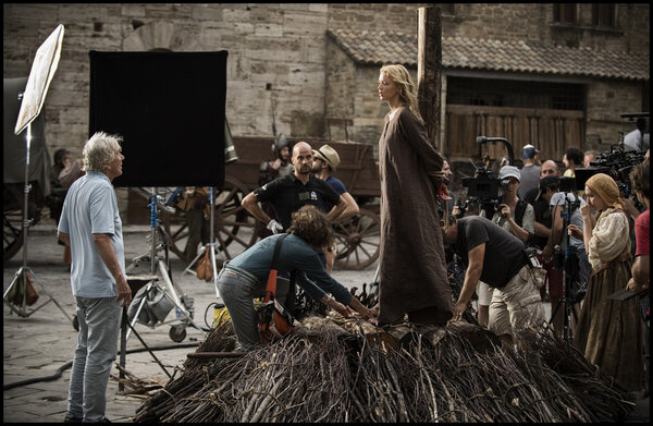 Paul Verhoeven, à gauche, et Jeanne Lapoirie, à droite à la caméra, casquette sur la tête, sur le tournage de la scène du bûcher