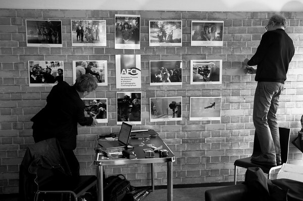 Marie Garric et Jean-Noël Ferragut installant les photos AFC sur le mur du pavillon de la CST