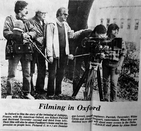 Newspaper article published in the USA during shooting of “Mississippi Blues” in 1982 - Insert discussing the twinning of Oxford, Mississippi with Aubigny-sur-Nère (Cher). From L to R: René Levert, Robert Parrish, Bertrand Tavernier, Pierre-William Glenn, at the viewfinder of the Arri 35BL, and Alain Choquart / Photo Alma Stead